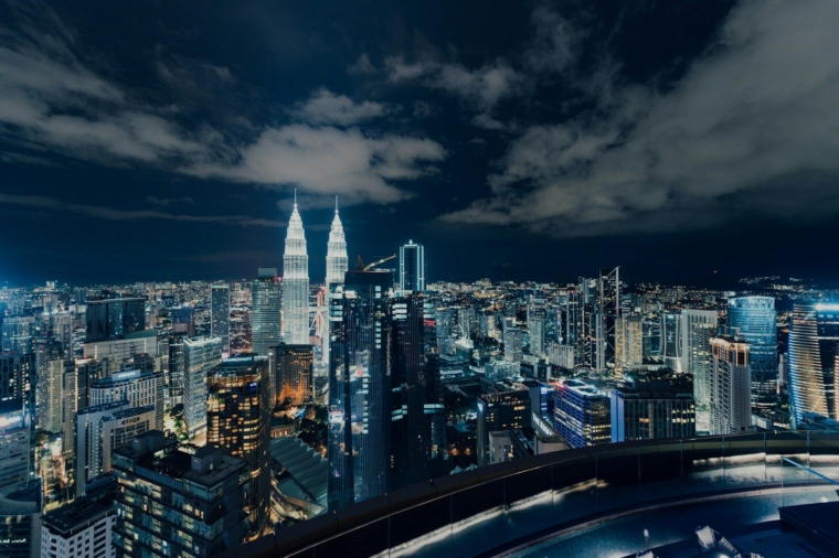city skyline under gray cloudy sky during night time