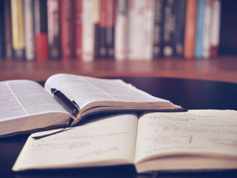 Student writing an AI research proposal for a Malaysian university postgraduate programme