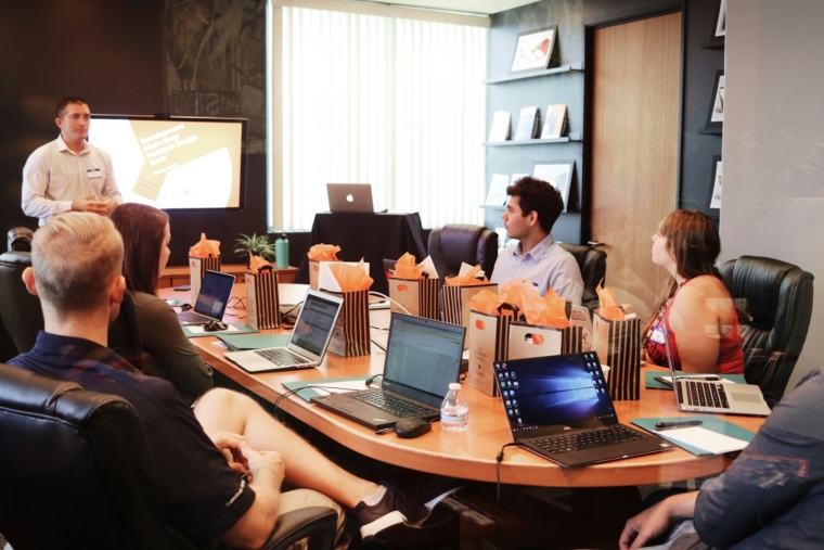 Trainer leading a generative AI workshop for a corporate team in Malaysia with participants working on laptops