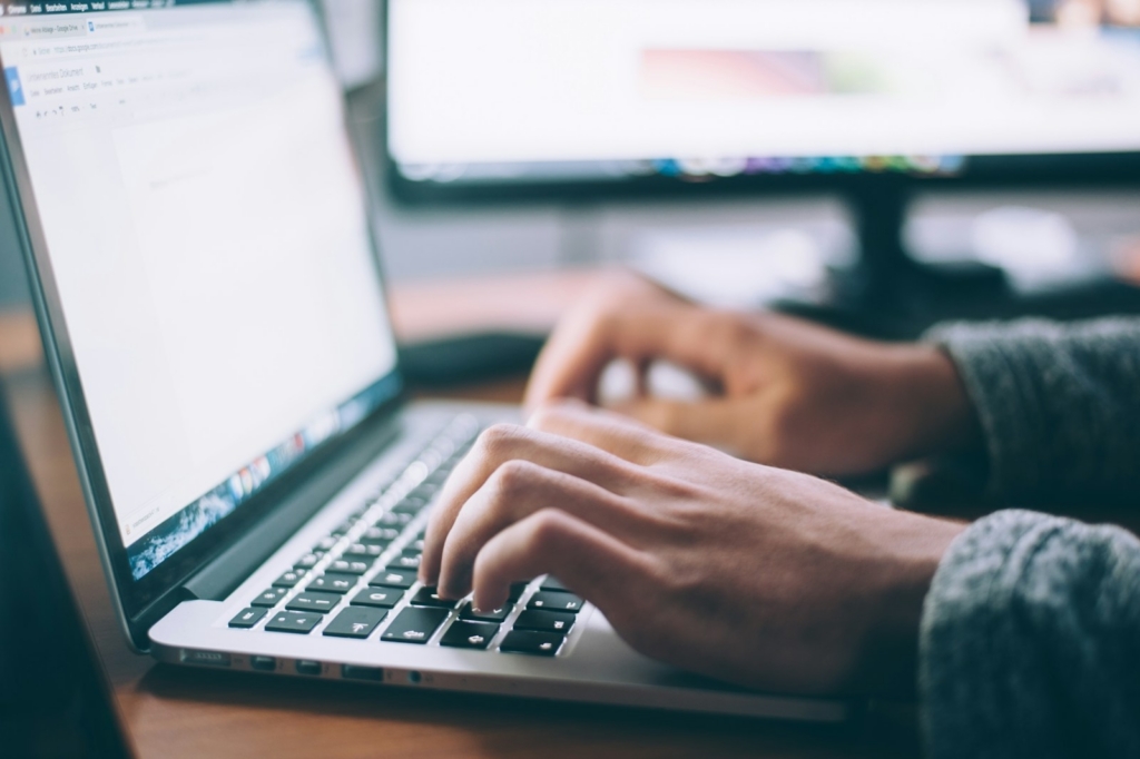Employee comparing online AI courses with live AI training in Malaysia on a laptop