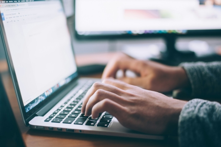 Employee comparing online AI courses with live AI training in Malaysia on a laptop