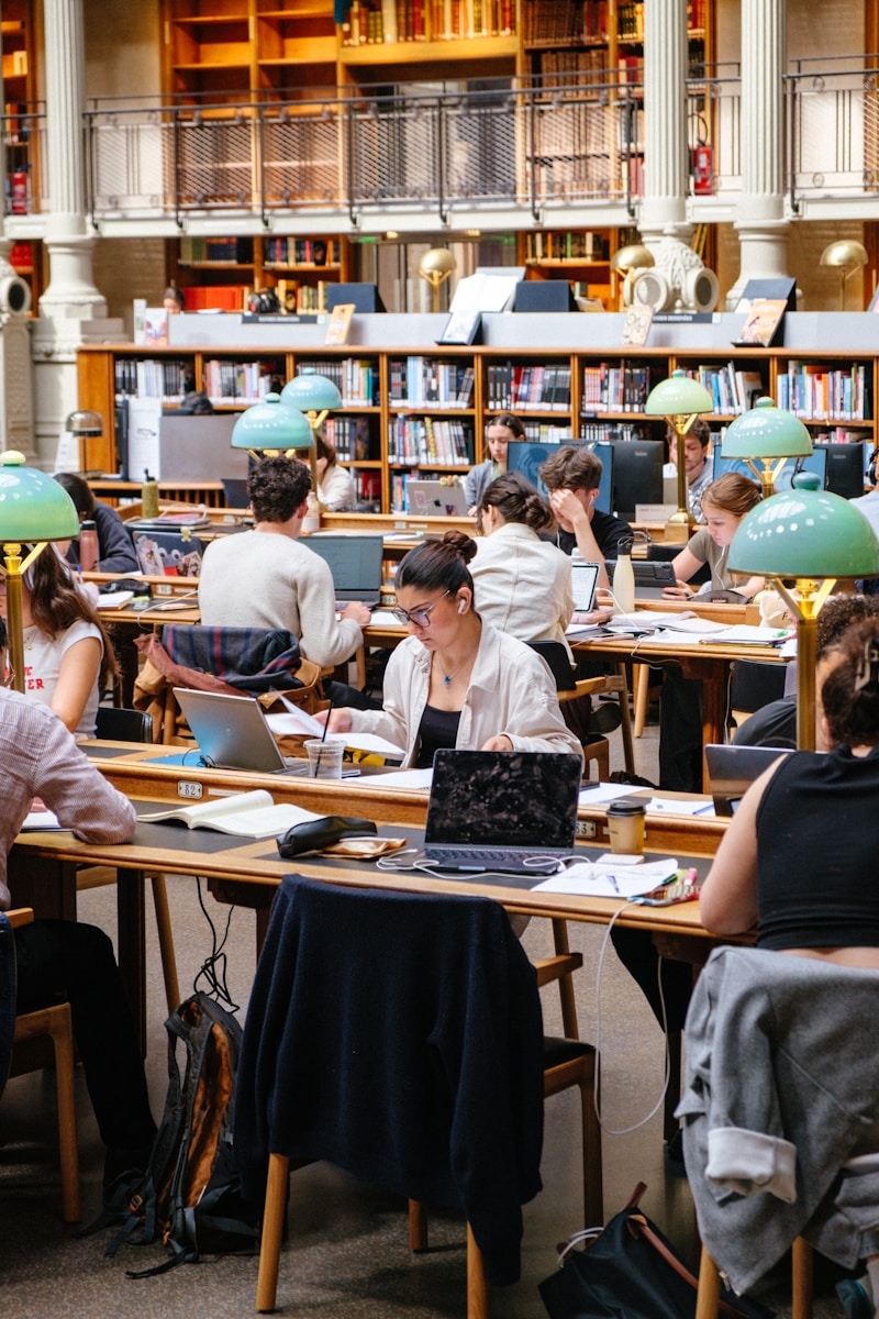 Postgraduate students screening primary studies during a systematic literature review in a university reading room
