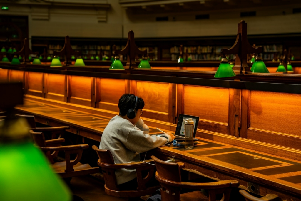 Postgraduate researcher conducting a systematic literature review in software engineering at a university library desk