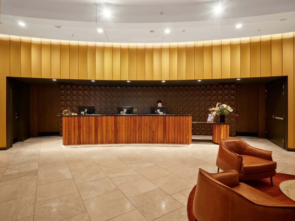 AI training for hospitality in Malaysia: hotel reception desk where front-office staff handle guest enquiries