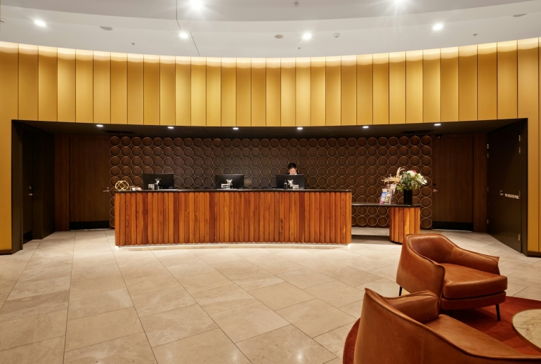 AI training for hospitality in Malaysia: hotel reception desk where front-office staff handle guest enquiries