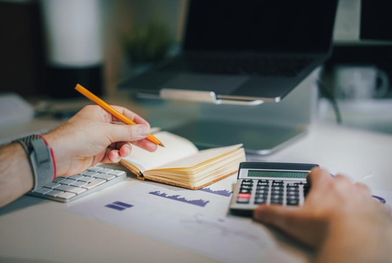 AI training for professional services in Malaysia: professional working at a desk with a calculator and notebook