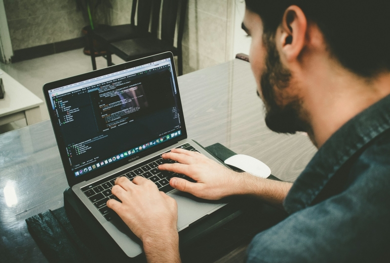 Software developer using an AI coding assistant on a laptop during AI training for developers in Malaysia