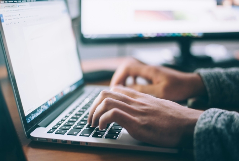 Employee comparing online AI courses with live AI training in Malaysia on a laptop